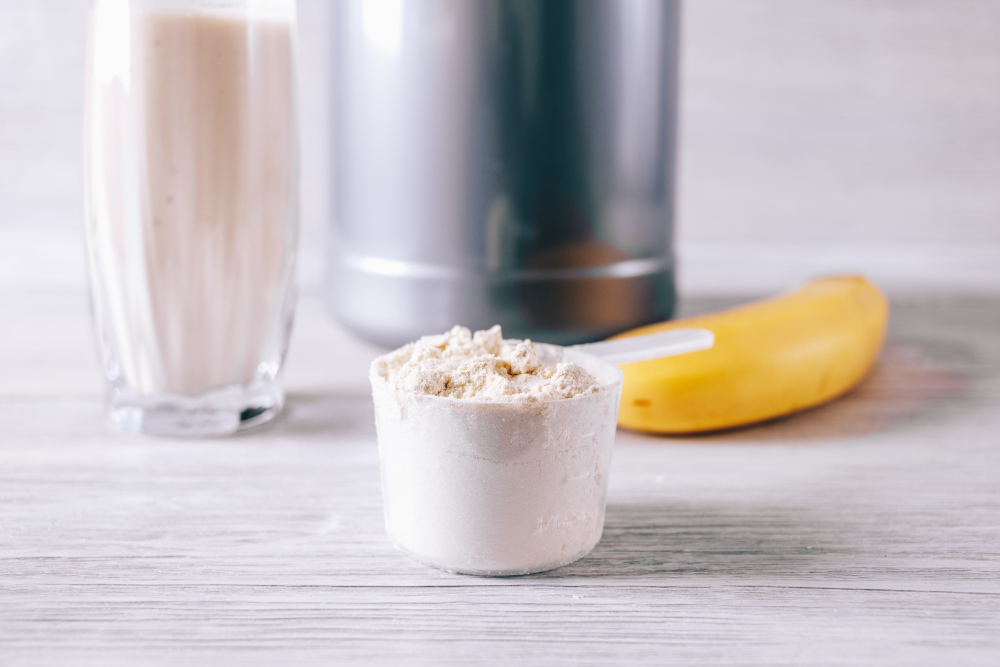 scoop with protein powder, banana and glass