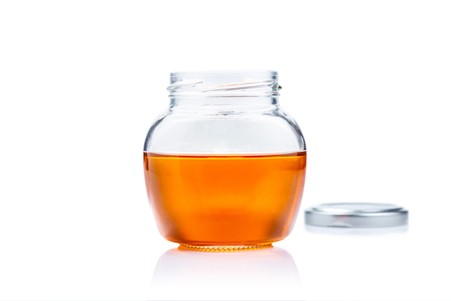 honey glass jar on white background with copy space