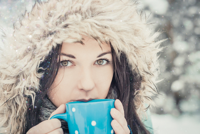 woman with big blue mug of hot drink during cold day.