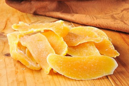 Dried mango or papaya slices on a wooden table